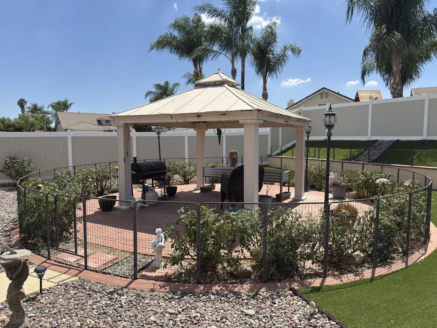 Backyard gazebo and rose garden after trimming and cleanup